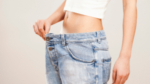 Pessoa mostrando a calça larga após grande perda de peso, representando a necessidade de cirurgia reparadora com o Dr. Alexandre Audi, cirurgião plástico em São Paulo.