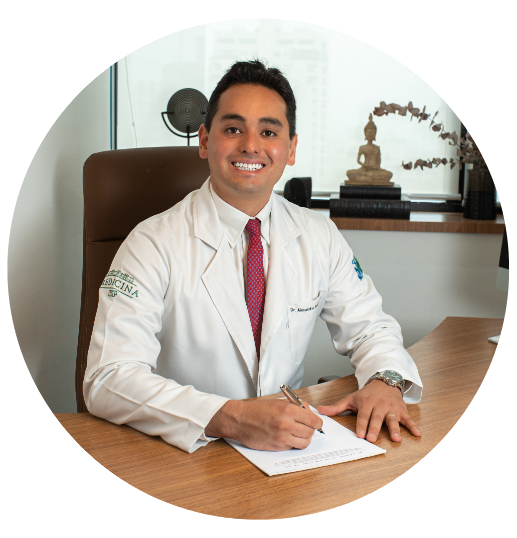 Dr. Alexandre Audi, cirurgião plástico em São Paulo, usando jaleco branco, sentado em seu consultório, sorrindo enquanto escreve em um prontuário médico.